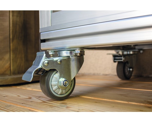 Wielen met rem op een metalen frame op een houten vloer