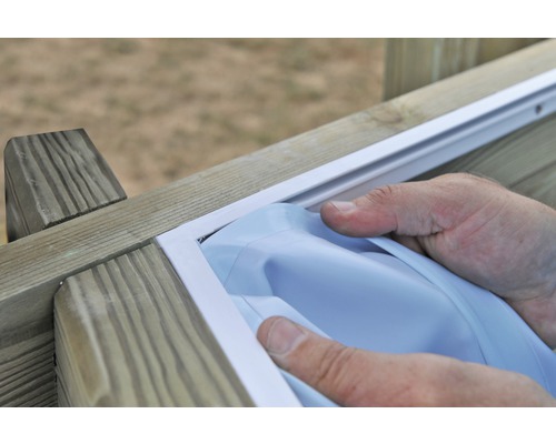 Persoon monteert een witte privacyfolie in een houten frame.