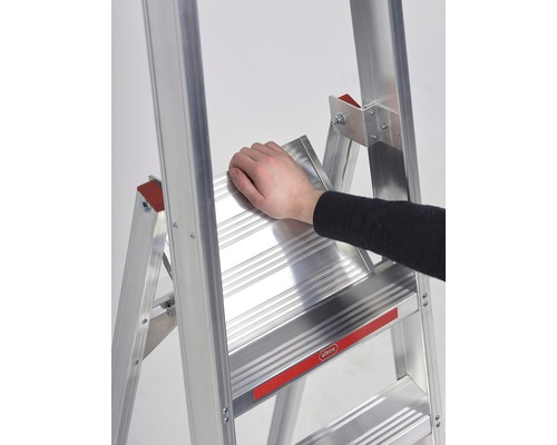 Detailopname van een aluminium trapladder met een hand op een trede