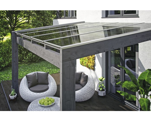 Houten terrasoverkapping met glazen dak en zitgroep in de tuin.