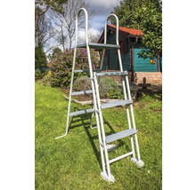 Metalen zwembadladder met vier treden in de tuin