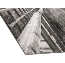 Close-up van een foto op een plaat, waarop een houten trap te zien is.