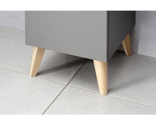 Detail van een grijze onderkast met houten poten