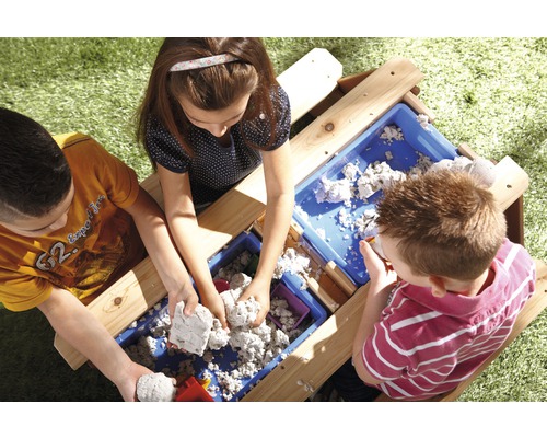 Kinderen spelen buiten met een modderkeuken, zand en bakken.