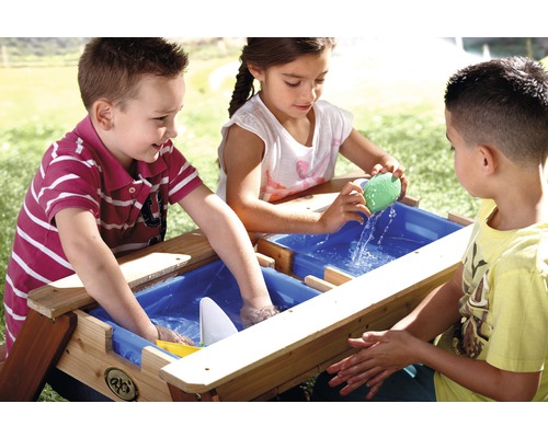 Kinderen spelen aan een houten zand- en watertafel buitenshuis