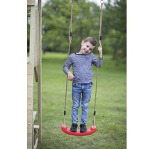 Jongen staat op een kinderschommel met touwen in de tuin.