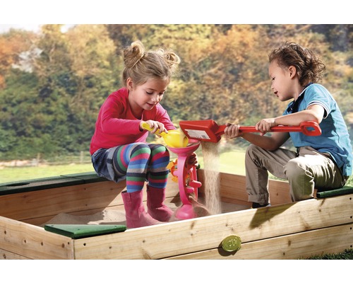 Twee kinderen spelen met zand in een zandbak met zandspeelgoed.