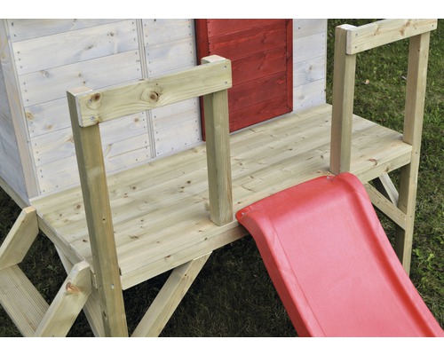 Detailopname van een houten speelhuis met glijbaan en hek