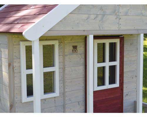 Detailopname van een houten speelhuis met ramen en een houten deur