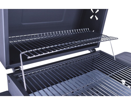 Detailopname van de binnenkant van de barbecue met grillrooster en warmhoudrooster.