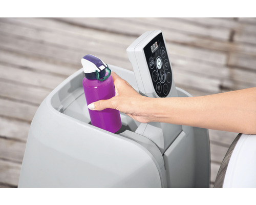 Vrouw plaatst drinkfles in bekerhouder bij bubbelbad