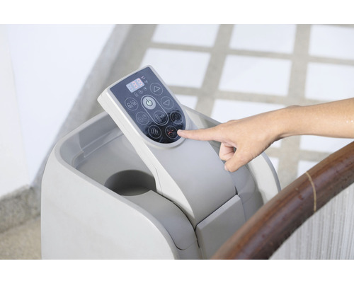 Bedieningspaneel van een sauna met een hand die op een knop drukt