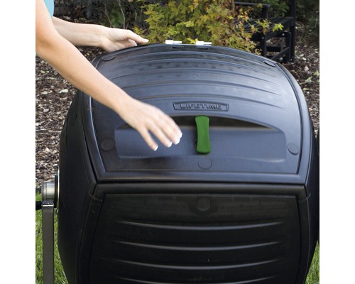 Close-up van een compostbak met een persoon die de bak opent