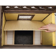 Detailopname van een vogelhuis met houten bekleding en openingsmechanisme.