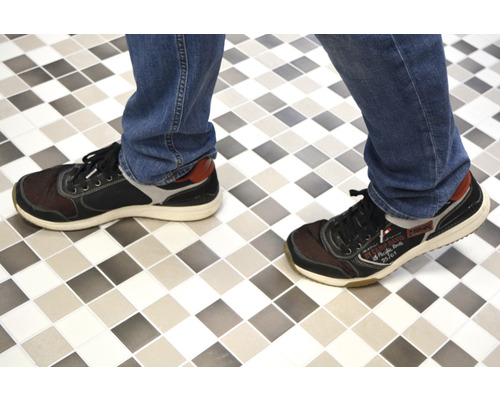 Persoon met schoenen op tegelvloer