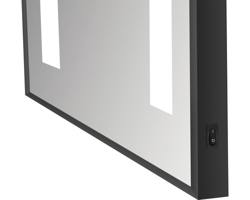 Detailopname van een spiegel met geïntegreerde verlichting en schakelaar