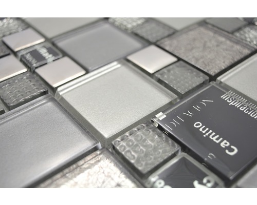 Close-up van glazen mozaïektegels in verschillende grijstinten en texturen.