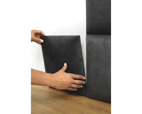 Persoon bevestigt akoestisch paneel aan de muur