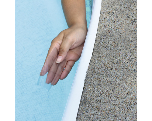 Hand in zwembadwater naast zwembad rand