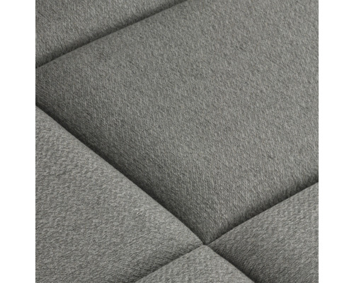 Close-up van een gestoffeerd meubelstuk met stoffen bekleding en gewatteerd patroon