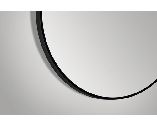 Gedeeltelijke afbeelding van een ronde spiegel met een zwarte lijst