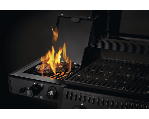 Zwarte gasbarbecue met steak en vlammen
