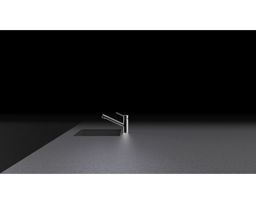 Metalen keukenkraan op aanrechtblad naast gootsteen