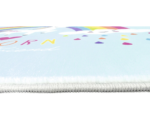 Close-up van een kindertapijt met eenhoornmotief en regenboog