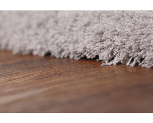 Detailweergave van een tapijt met bruine houten vloer