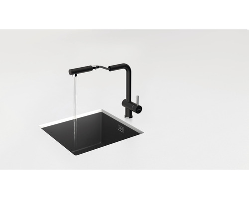 Zwarte keukenkraan met uittrekbare sproeikop boven een spoelbak