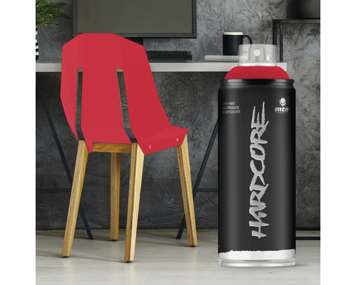 Spuitbus met rode verf naast stoel