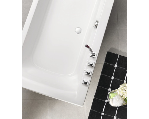 Bovenaanzicht van een wit bad met kraan en een badmat