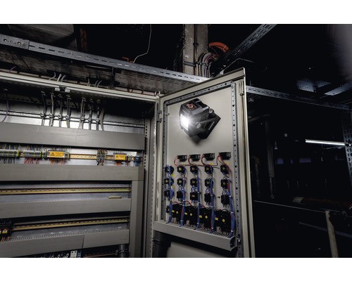 Binnenaanzicht van een open schakelkast met een werklamp