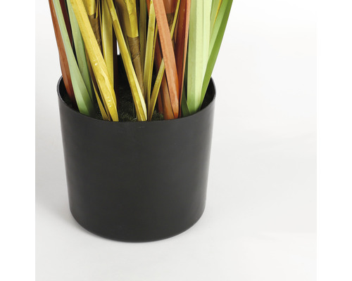 Decoratieve kunstplant in een zwarte plantenbak.