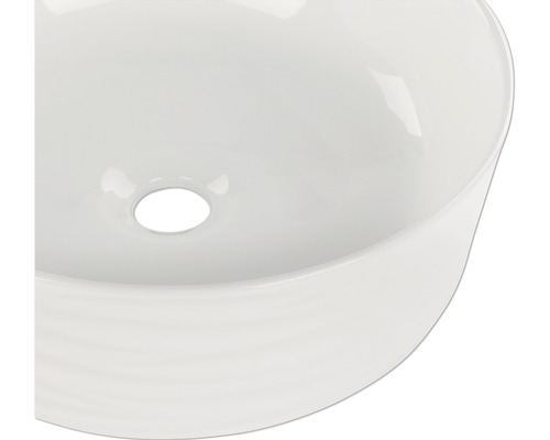 Bovenaanzicht van een ronde keramische wastafel met afvoer