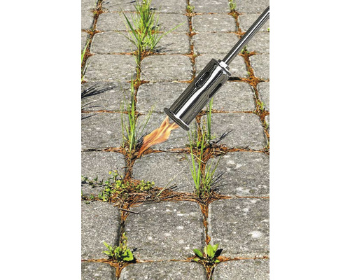 Onkruidbrander in gebruik op bestrating voor onkruidbestrijding