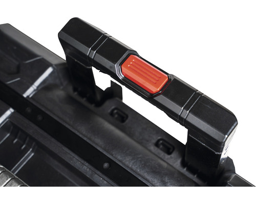 Detailweergave van het handvat van een gereedschapskoffer met rode knop