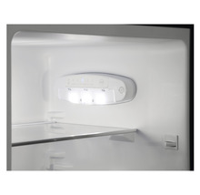 Interieur van een koelkast met LED-verlichting en glazen plank