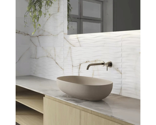 Badkamer met waskom, kraan en wandtegels in marmerlook.