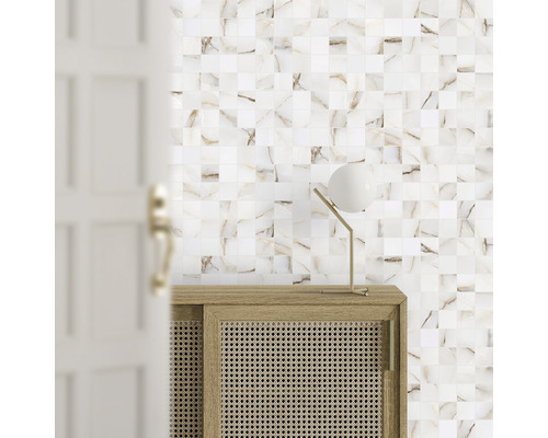 Scène met mozaïektegels op de muur, een houten kast en een lamp.