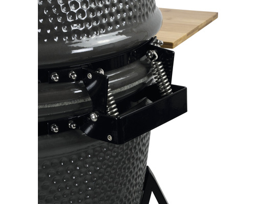 Detailopname van een keramische barbecue met veermechanisme en bamboe plank