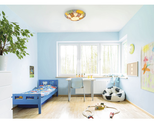 Helder verlichte kinderkamer met een blauw bed, een bureau en een plafondlamp met dierenmotieven.
