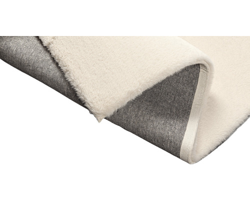 Detailopname van een vloerkleed met pool en geweven achterkant