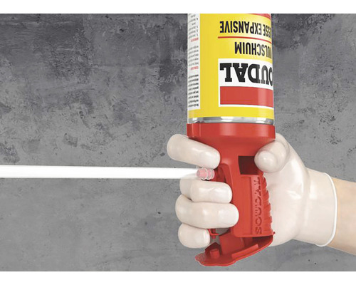 Een hand met handschoen bedient een bus montageschuim met pistool.