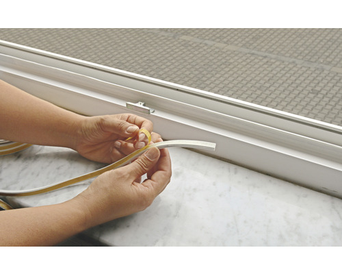 Persoon verwijdert beschermfolie van afdichtingsband voor raamafdichting