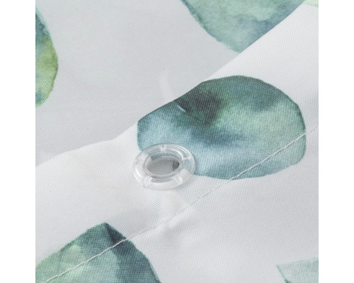 Detailopname van een douchegordijn met plantenpatroon en oogje voor ophanging.