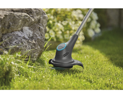 Gras trimmer in gebruik op gazon in de tuin.