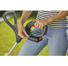 Een vrouw bedient een grastrimmer met accu