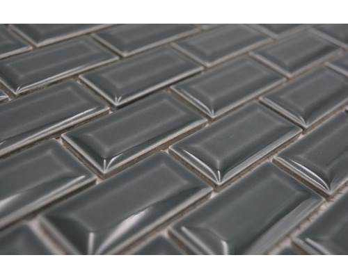 Close-up van grijze, rechthoekige tegels in visgraatmotief