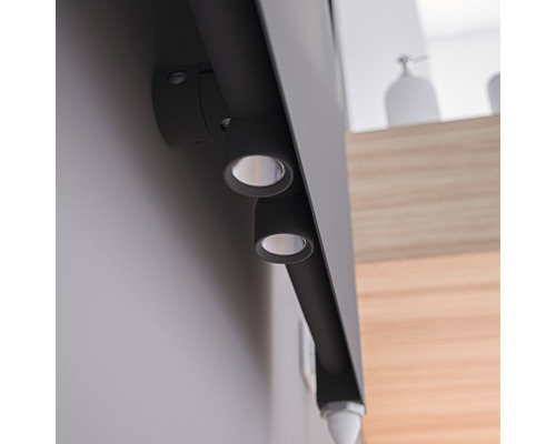 Foto van een grijze opbouwlamp met twee spots in een interieur